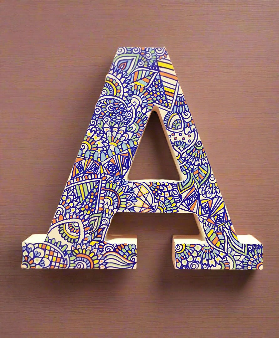 A white Letter A with doodles drawn in Blue and colored in green, orange blue and yellow