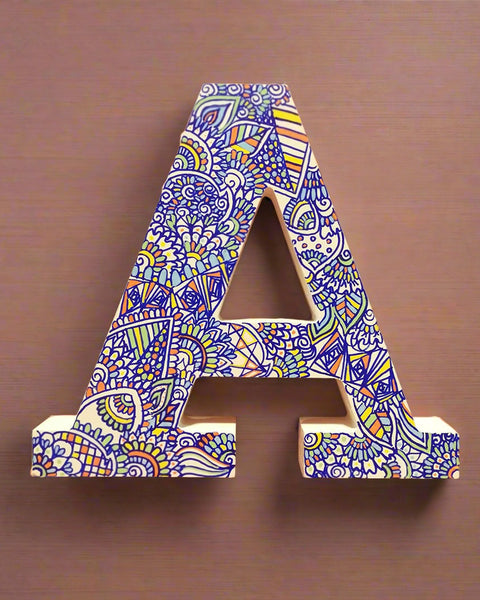 A white Letter A with doodles drawn in Blue and colored in green, orange blue and yellow