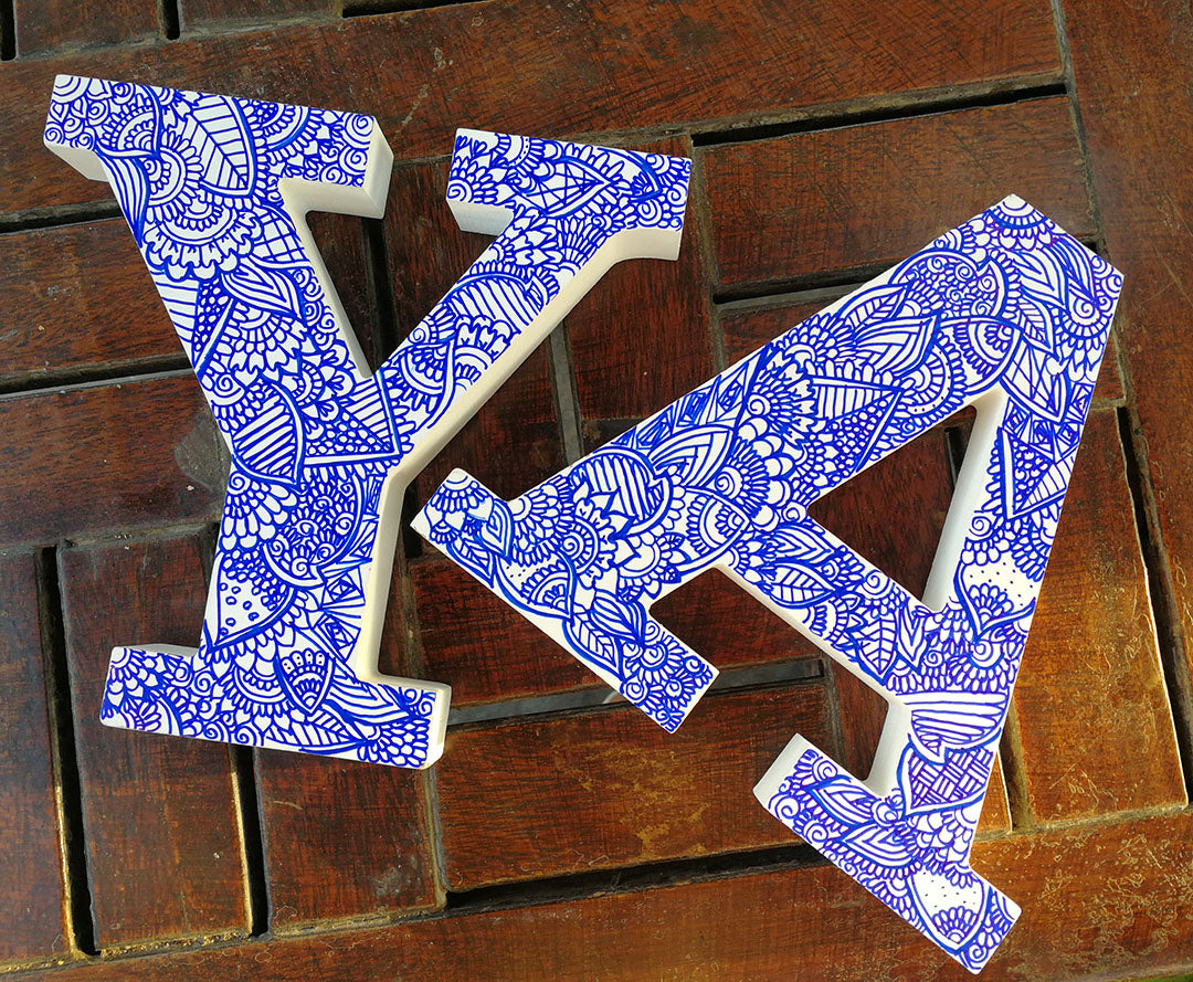 A white Letter A and Y with doodles drawn in blue