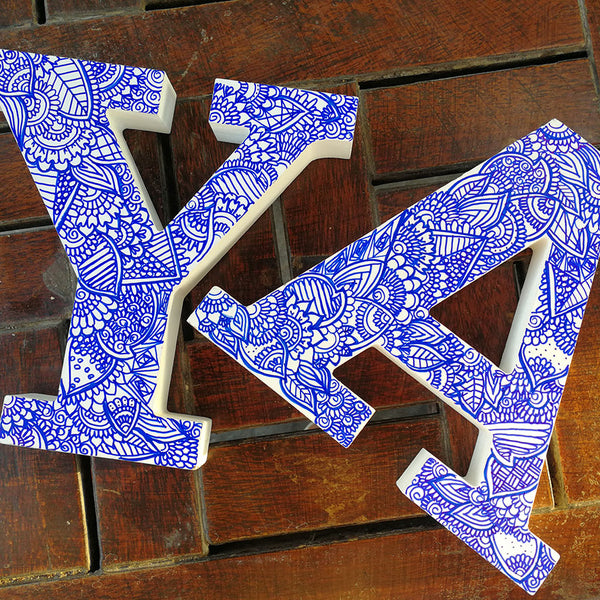 A white Letter A and Y with doodles drawn in blue