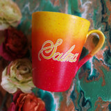 A Gradient hand painted mug from yellow to orange to red , with the name 