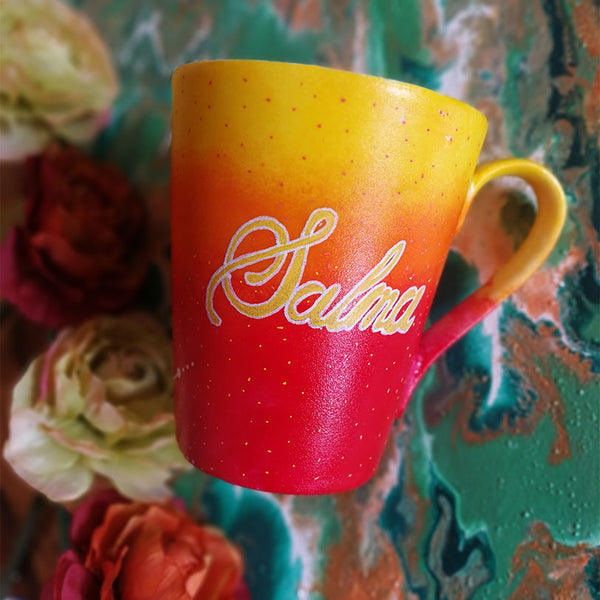 A Gradient hand painted mug from yellow to orange to red , with the name "Salma"