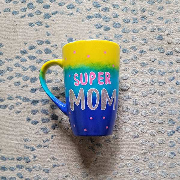 A Gradient colored mug (Yellow blue and ultramarine) with the words "Super Mom" with pink dots scattered all over