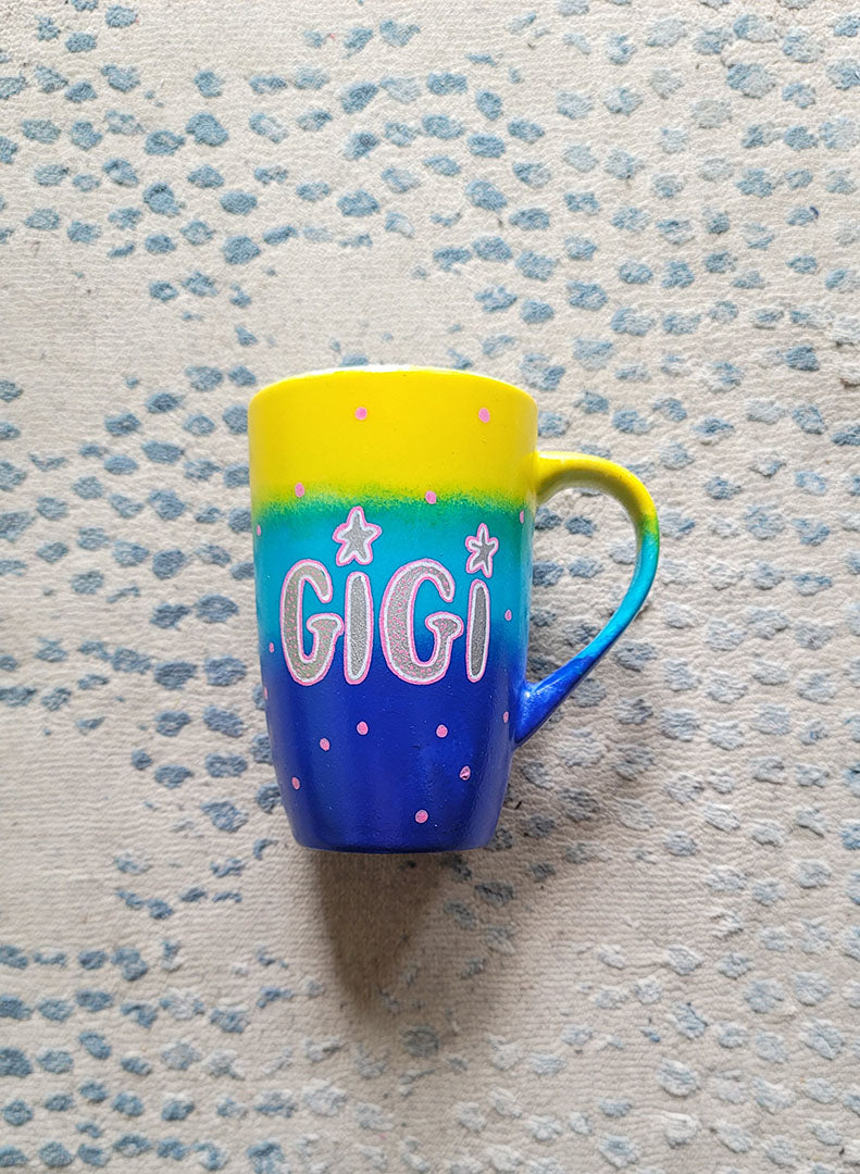 A Gradient colored mug (Yellow blue and ultramarine) with the name "GiGi" with pink dots scattered all over