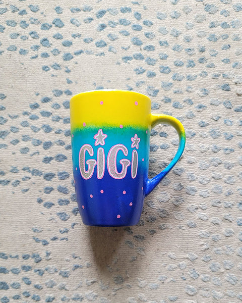 A Gradient colored mug (Yellow blue and ultramarine) with the name "GiGi" with pink dots scattered all over