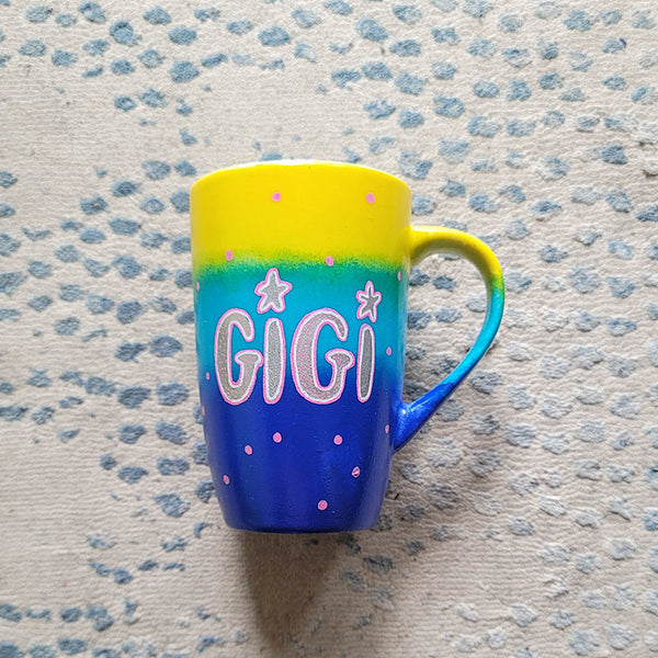 A Gradient colored mug (Yellow blue and ultramarine) with the name "GiGi" with pink dots scattered all over