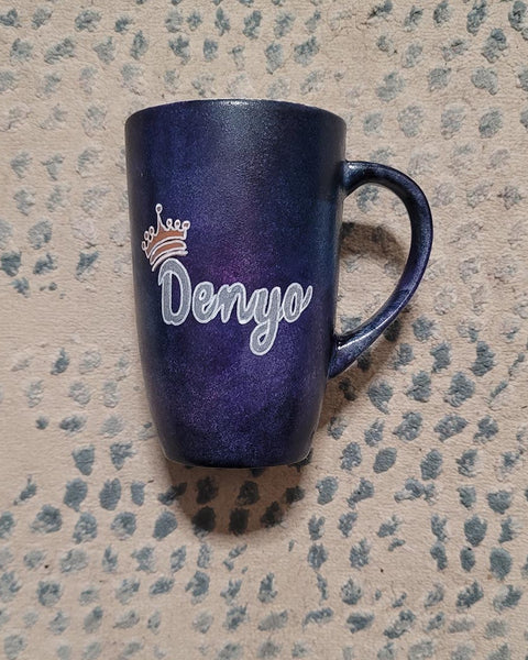 A dark sky hand painted mug with the name "Denyo" and a little crown above the letter D