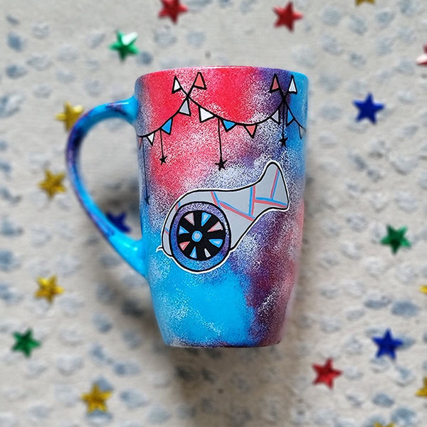 A Blue Red Hand painted mug with decorations hanging from the top all around the mug and a Madfa3 painted in black grey, blue and red