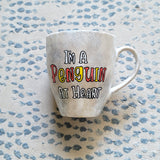 A Taupe hand painted mug with the words 