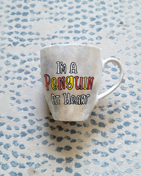 A Taupe hand painted mug with the words "I'm a penguin at heart"