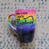 A Mug with the top half painted in rainbow and the bottom in dark galaxy, with the words on the rainbow written 