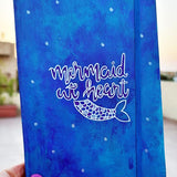 A blue hand painted Notebook with the words 