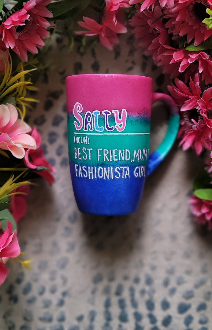 A gradient colored mug (from top fushia then green then blue) with the name sally wirten and then a white line underneath it and then the words Noun in brackets and below it "Best friend, Mum, fashionista Girl"