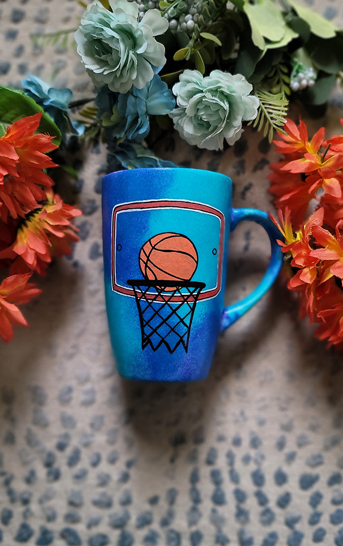 A Blue Hand painted mug with a drawing of a basketball in the net