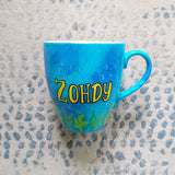 A Blue hand painted mug with the name 