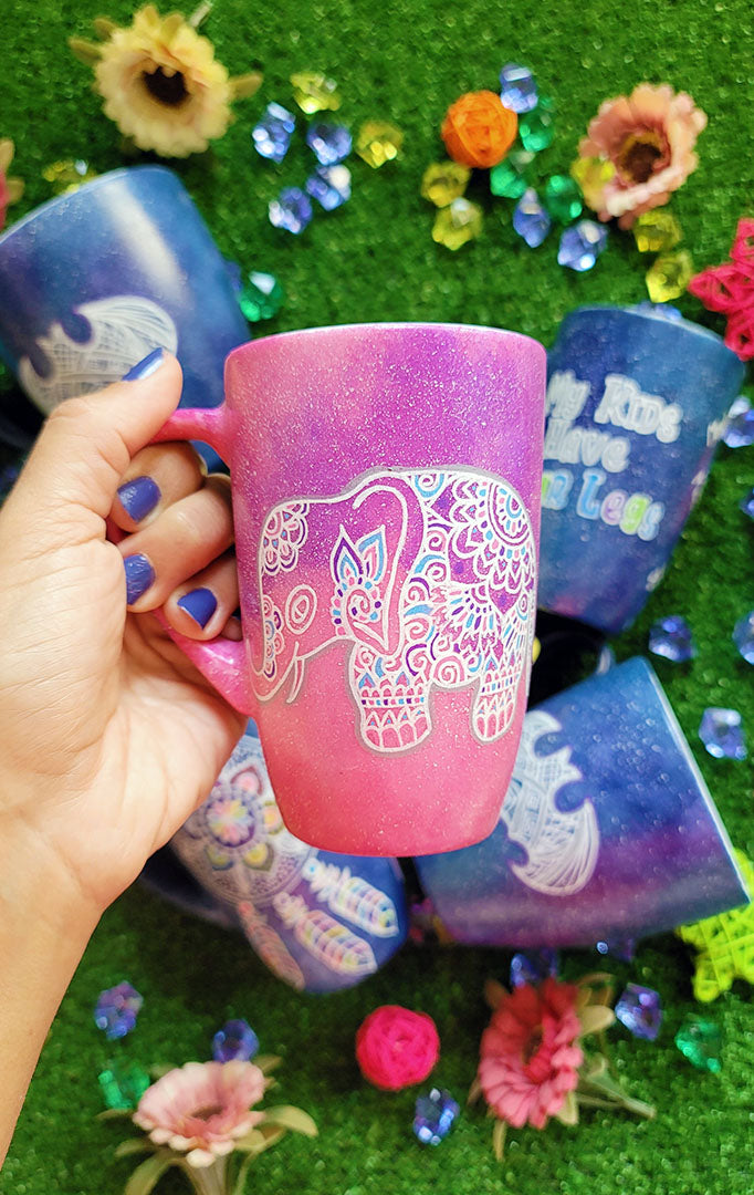 A Pink Galaxy hand painted mug with an elephant zentangle design on it in white