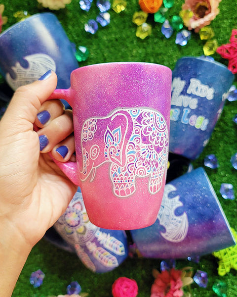 A Pink Galaxy hand painted mug with an elephant zentangle design on it in white