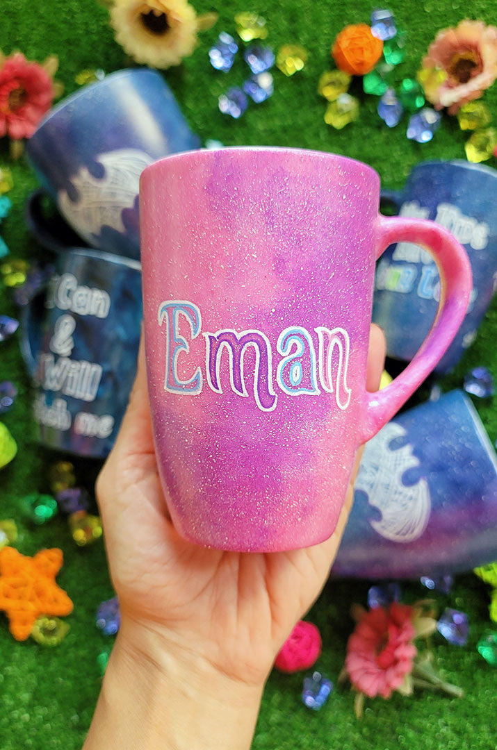 A Pink Galaxy hand painted mug with an the name "Eman"