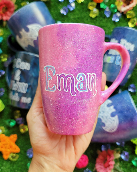 A Pink Galaxy hand painted mug with an the name "Eman"