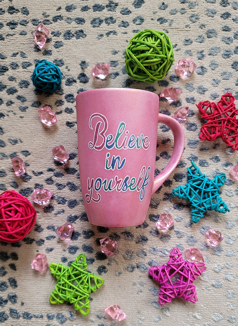 A Shimmery Pink hand painted mug with the words "Believe in yourself"