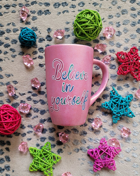 A Shimmery Pink hand painted mug with the words "Believe in yourself"