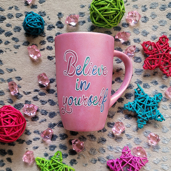 A Shimmery Pink hand painted mug with the words "Believe in yourself"