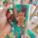 A Christmas hand painted mug with aa gingerbread cookie girl on it with a bow