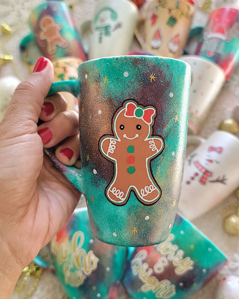 A Christmas hand painted mug with aa gingerbread cookie girl on it with a bow