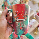 A Christmas galaxy hand painted mug with a reindeer antlers with a santa hat and reindeer ears, then below it the name 