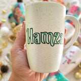 A pearl white hand painted mug with the name 