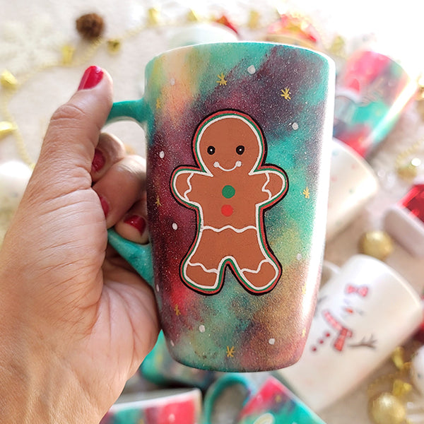 a christmas colored hand painted mug with a gingerbread cookie boy painted on it