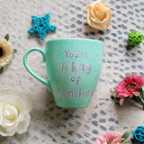 A Mint green handpainted mug with the words 