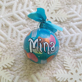 A Colorful hand painted ornament with turquoise bubbly background and colors of bubbly, pastel orange, pastel pink and silver scattered all over with white dots and the name 