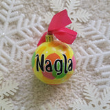 A Colorful hand painted ornament with yellow background and colors of pink, orange, green and yellow scattered all over with white dots and the name 