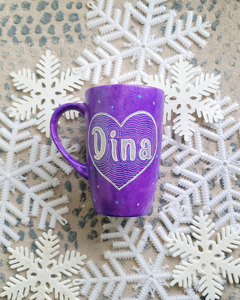 A Purple Galaxy hand-painted mug with a heart painted and the name "Dina" written inside in silver