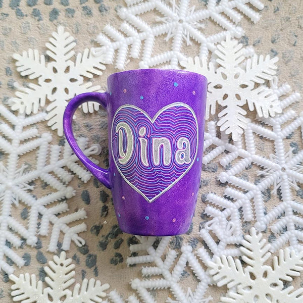 A Purple Galaxy hand-painted mug with a heart painted and the name "Dina" written inside in silver