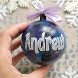 A Black galaxy hand painted ball ornament with the name 