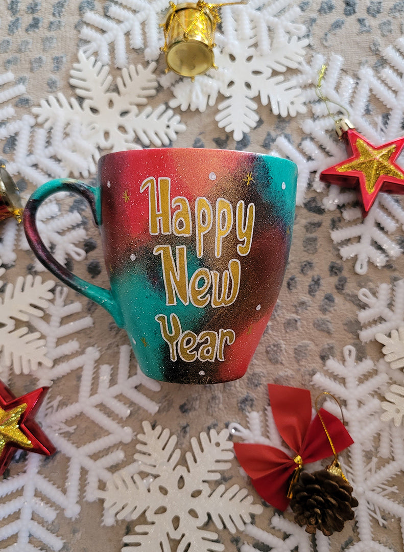 A Christmas galaxy colored hand painted mug with the words "Happy new year" written in gold and white dots and gold stars scattered all over