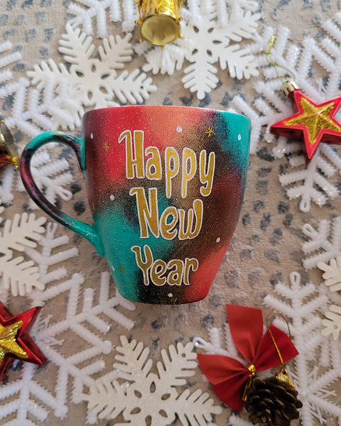 A Christmas galaxy colored hand painted mug with the words "Happy new year" written in gold and white dots and gold stars scattered all over