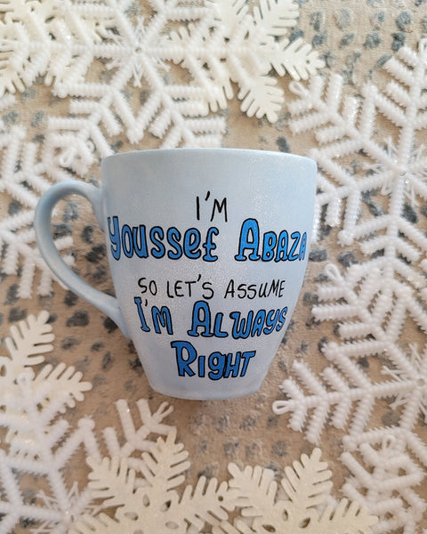 A baby blue hand painted mug with the words "I'm Youssef Abaza,  So lets Assume I'm Always right"