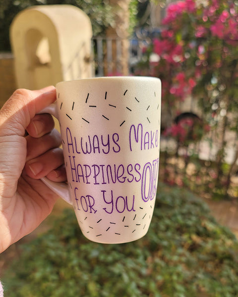 A white pearl hand painted mug with the words "Always Make Happiness ok for you " in purple and black sprinkles scattered all over the mug