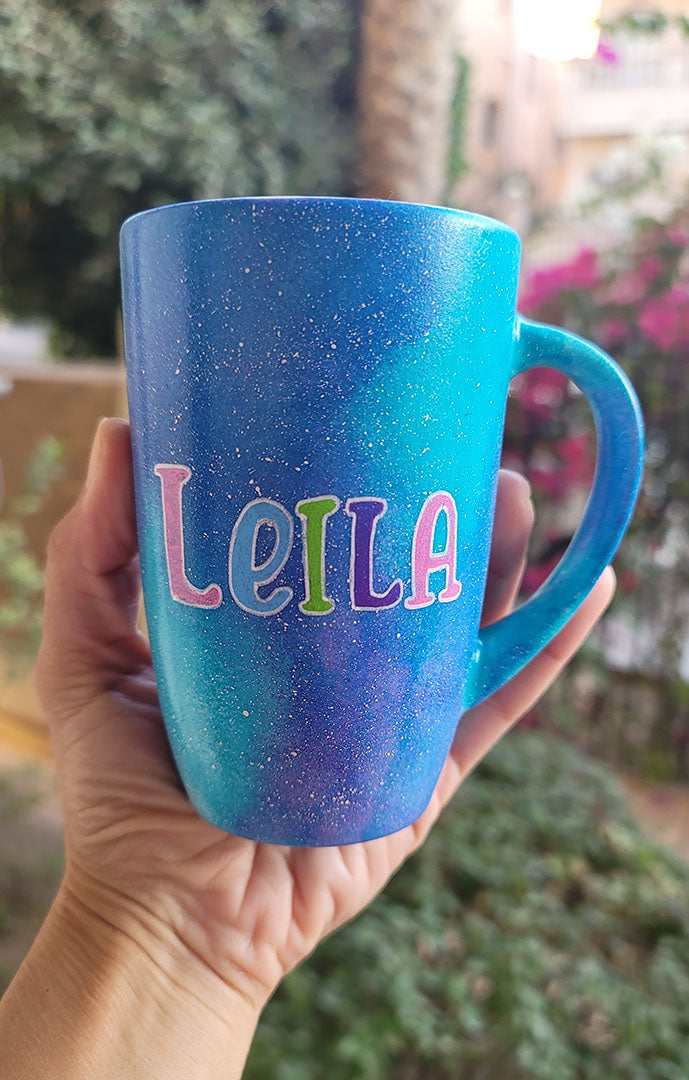 A Blue Galaxy Mug with the words name "Leila"