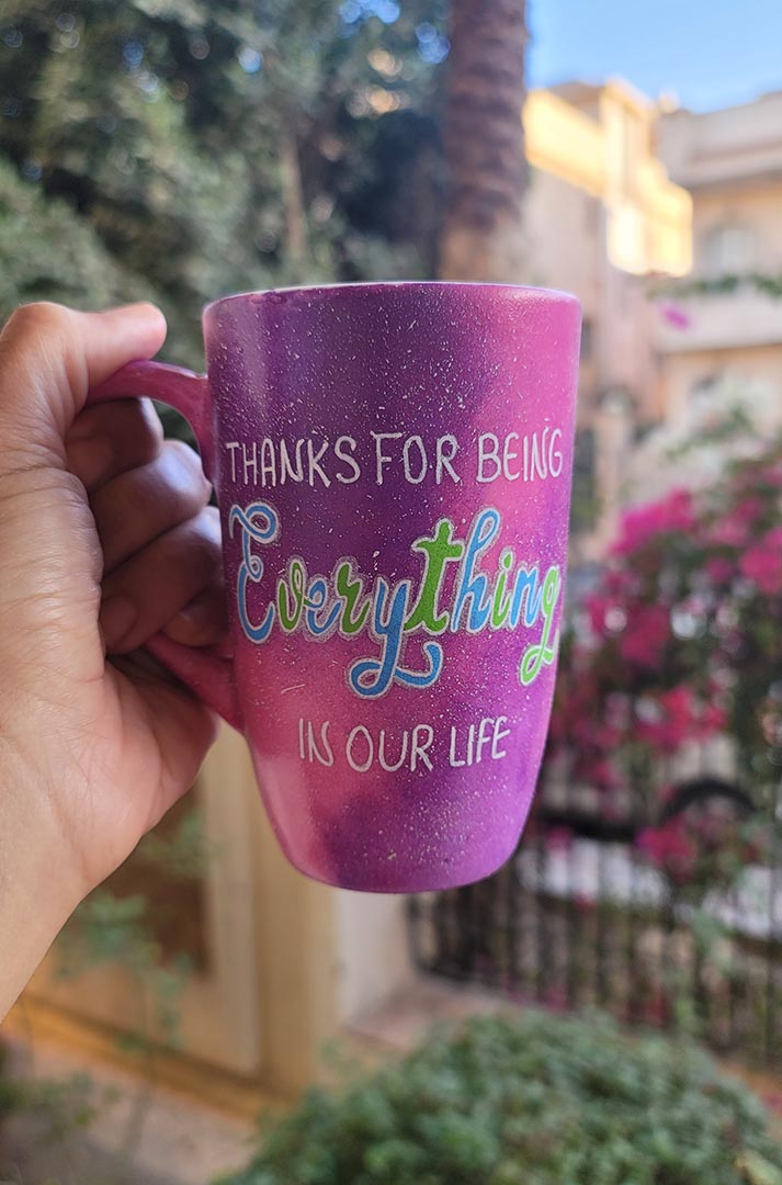 A hand painted pink galaxy mug with the sentence "thanks for being everything in our life"