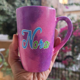 A hand painted pink galaxy mug with the name 