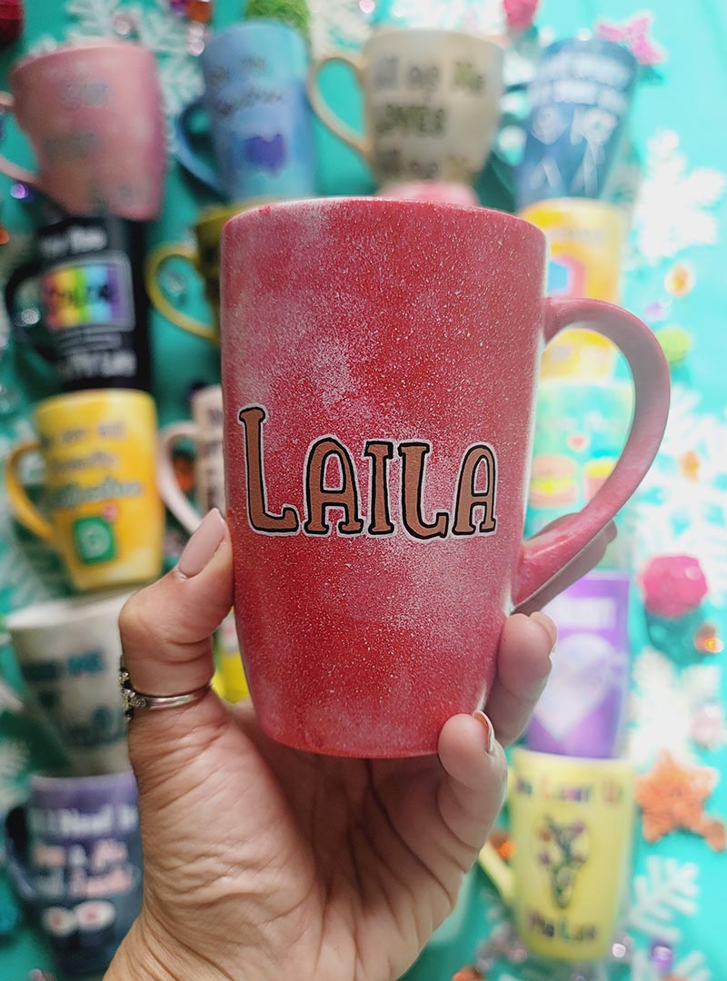 A red galaxy hand painted mug with the name "Laila"