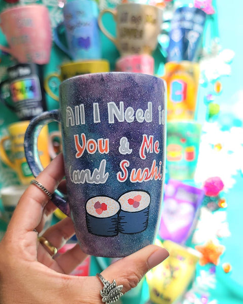 A Hand Painted Black Galaxy Mug with the sentence "All I need is You and ME and Sushi" and 2 sushi rolls drawn below it