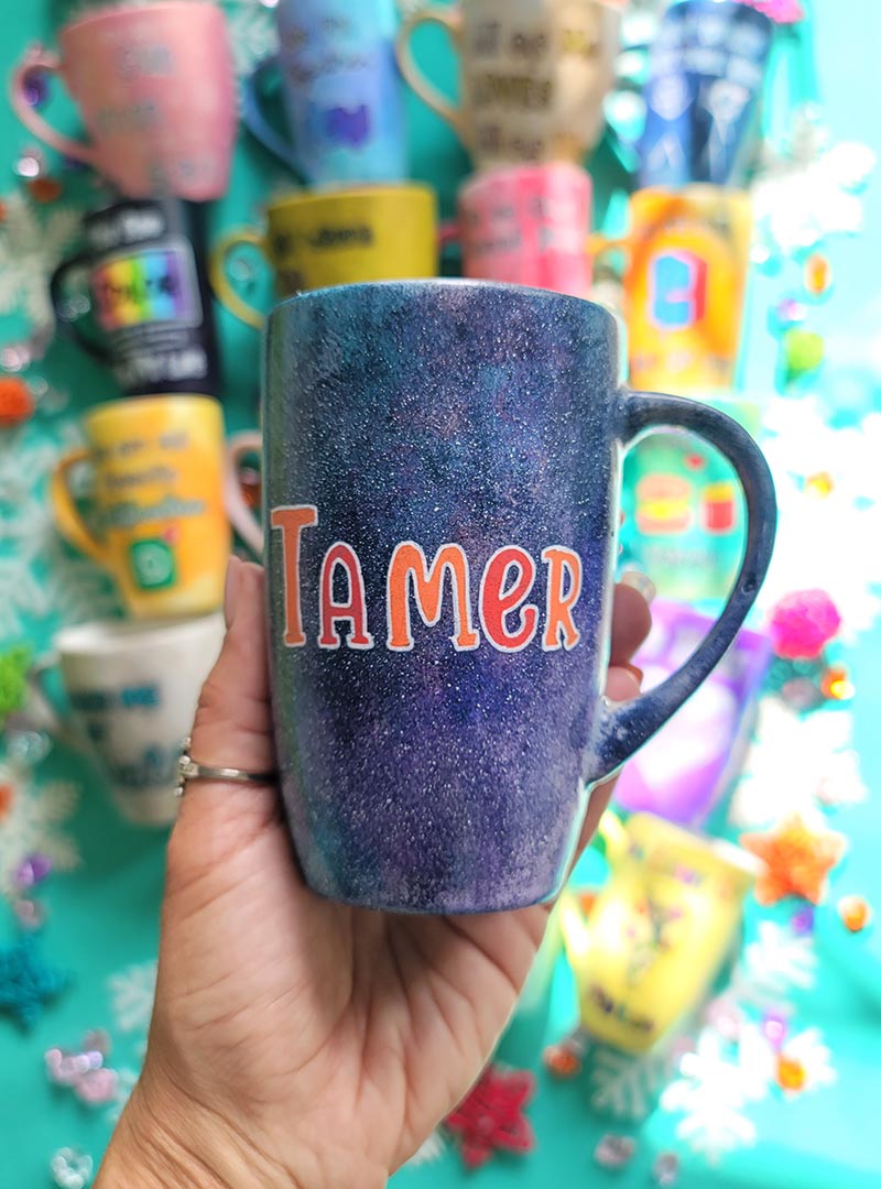 A Hand Painted Black Galaxy Mug with the name "Tamer"