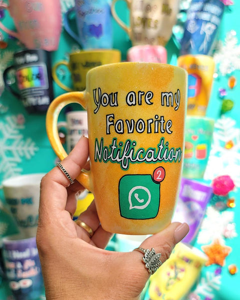 A yellow orange hand-painted mug with the words "You are my favorite notification"