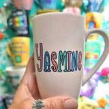 A pale pink mug with the name 