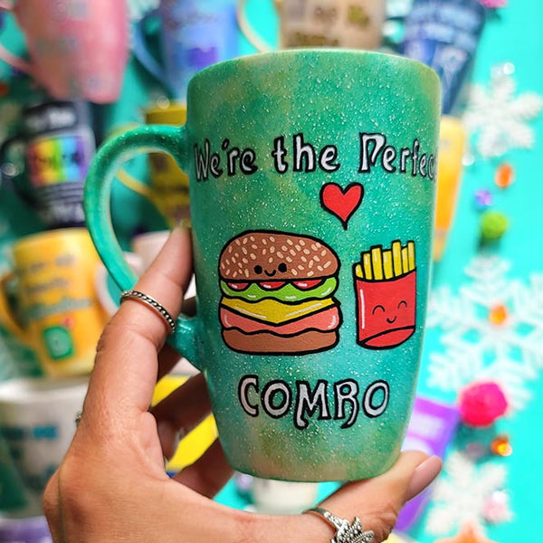 A hand-painted green galaxy mug with the words "we're the perfect combo"